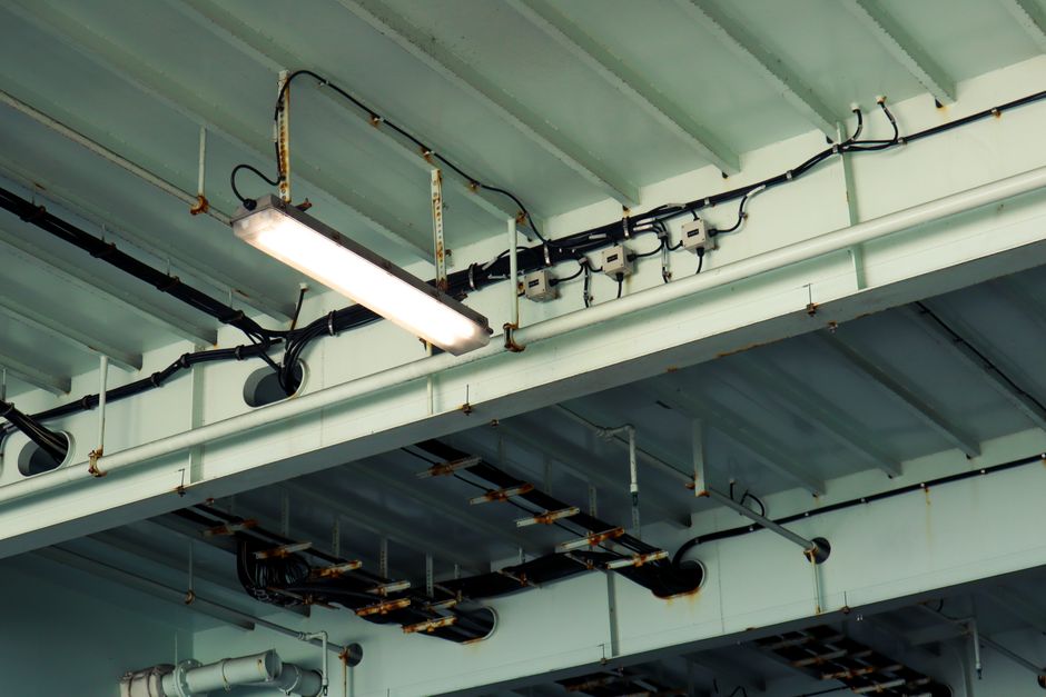 Ceiling with exposed cabling, conduit, and lighting in a commercial building