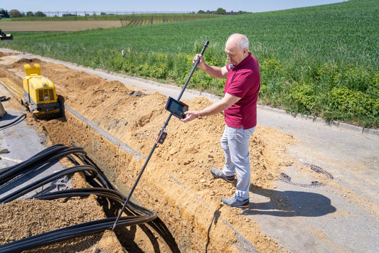 Engineer surveying a trench during underground cable installation